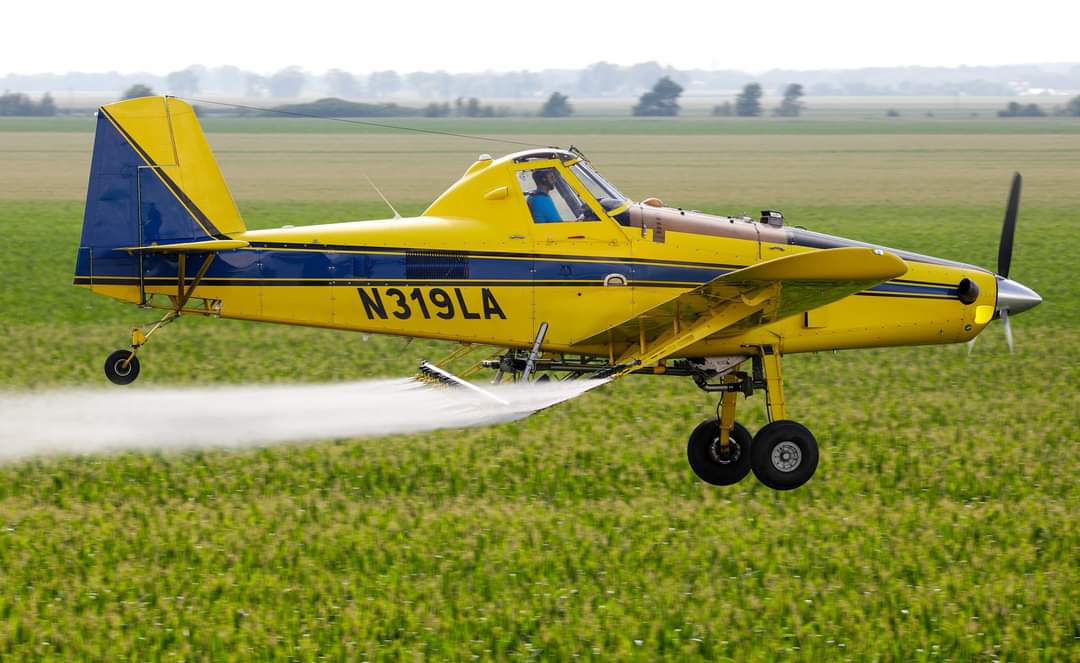 Justin Rudd flying the crop duster over a field
